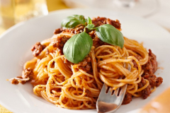 spaghetti with basil garnish in meat sauce